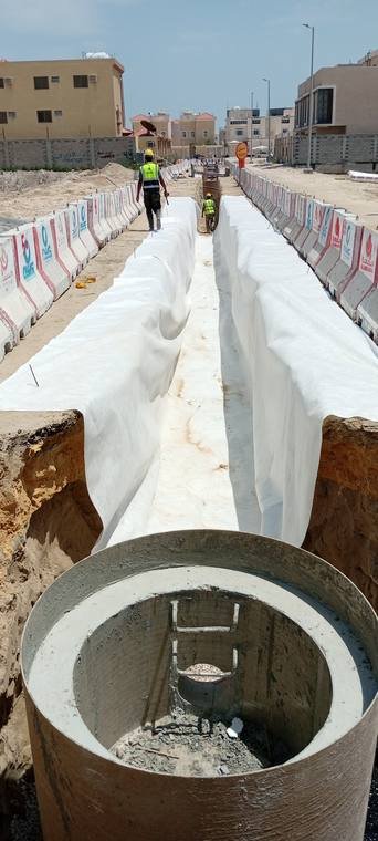 شركة وادي البناء الحديث – غرفة تفتيش خرسانية جاهزة للتركيب بجوار خندق مبطّن بالطبقة الجيوتكستيلية.